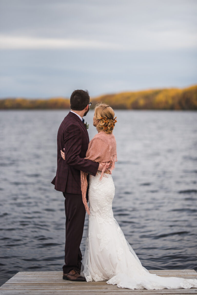 Les mariés se collent au bord du lac en automne près de l'Espace Shawinigan