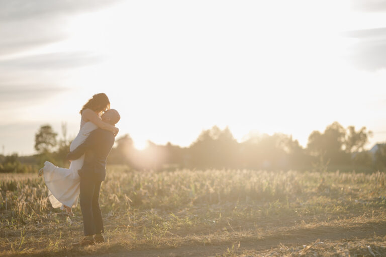 He lifts her into a cornfield at golden hour sunset
