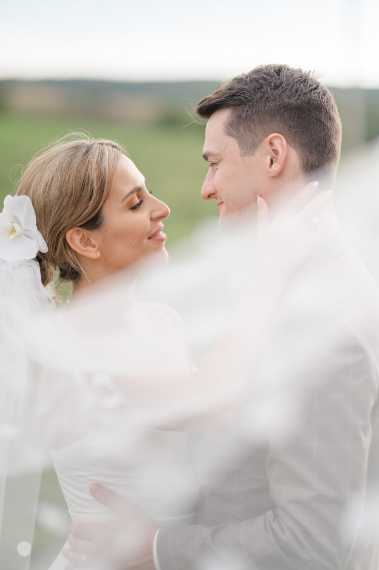 Le photographe joue avec le voile pour une magnifique photo des mariés