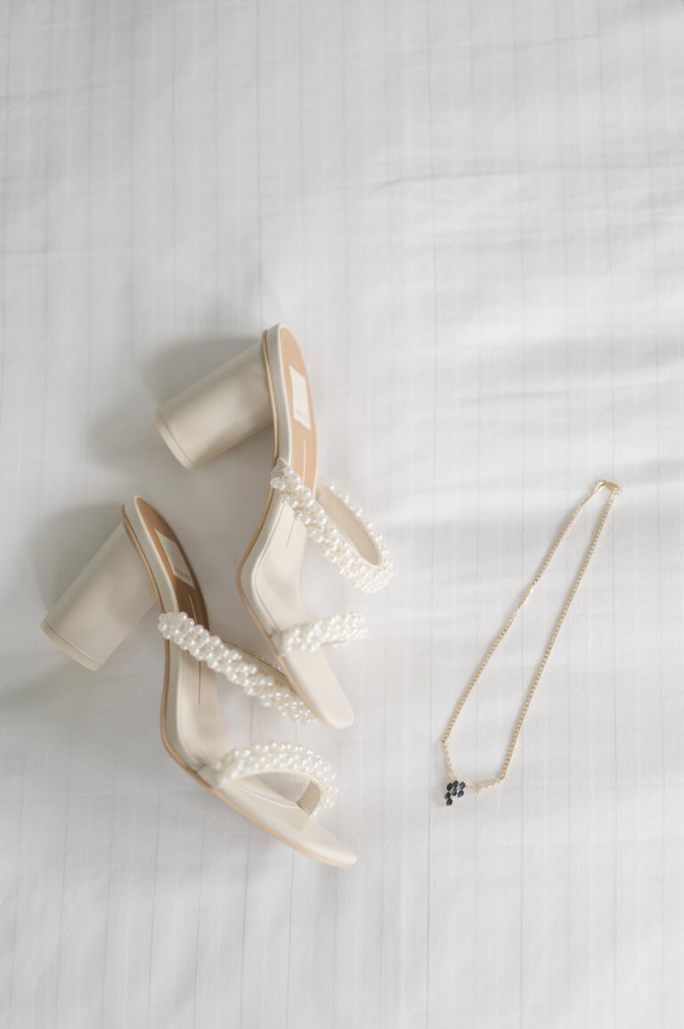 Les souliers et les bijoux de la mariée sur fond blanc