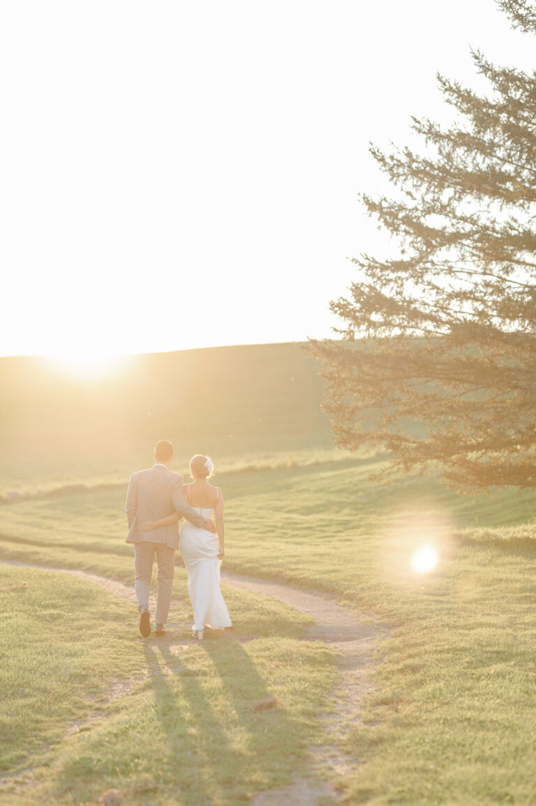 The bride and groom walk peacefully through the golden hour