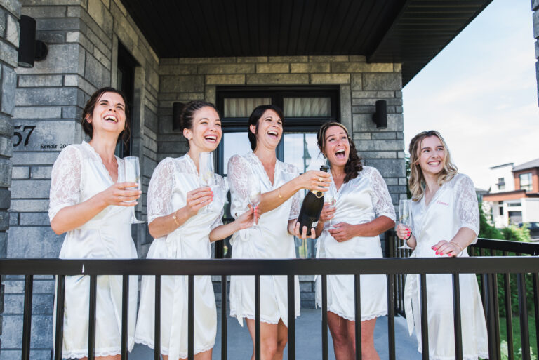 Bride and bridesmaids pop champagne in bathrobes