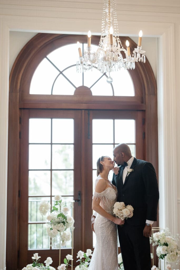 Les mariés s'embrassent dans une salle luxueuse du Manoir Richelieu qui accueille des mariages avec hébergement haut de gamme.