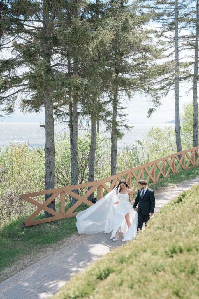 Le voile de la mariée vole dans le vent dans ce prestigieux mariage au Manoir Richelieu au bord du Fleuve St-Laurent dans la ville de La Malbaie